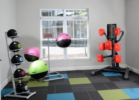 A room with a black and white checkered floor and a weight rack with red weights.