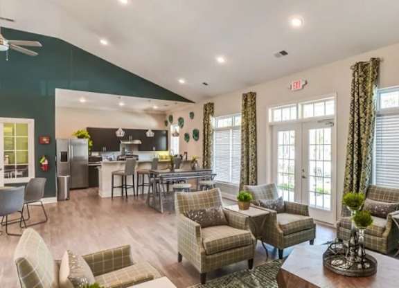 A living room with a variety of seating options and a dining area in the background.