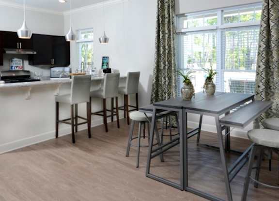 A kitchen with a table and chairs.