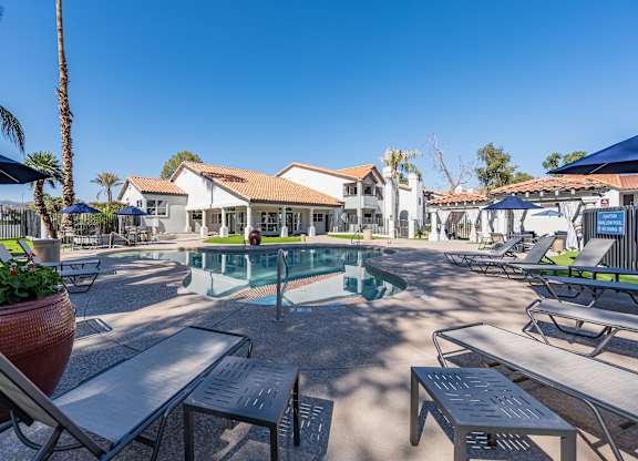 a pool with tables and chairs around it at the resort
