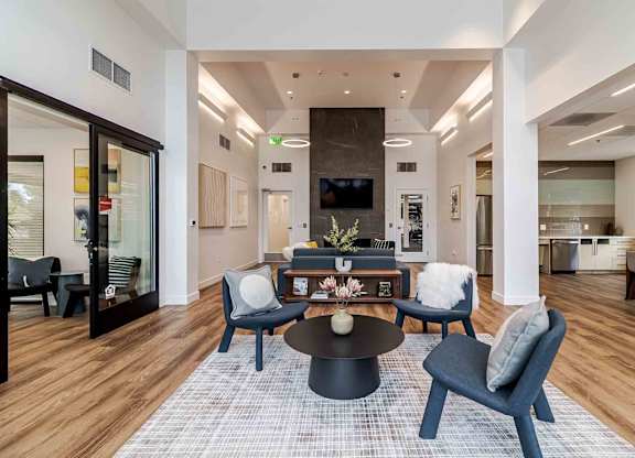 A modern living room with a black coffee table and blue chairs.