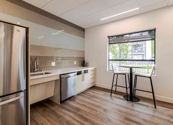 A kitchen with a refrigerator, sink, and dishwasher.