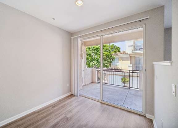 a spacious living room with sliding glass doors to a balcony