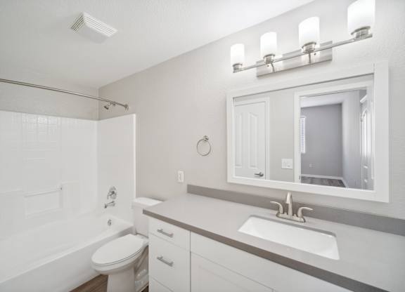a bathroom with a sink and a tub and a mirror