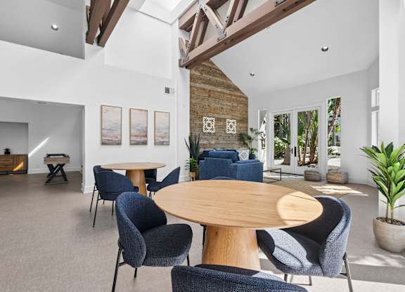 A living room with a wooden table surrounded by chairs.