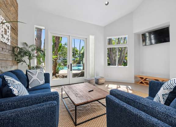 A living room with blue couches and a wooden coffee table.