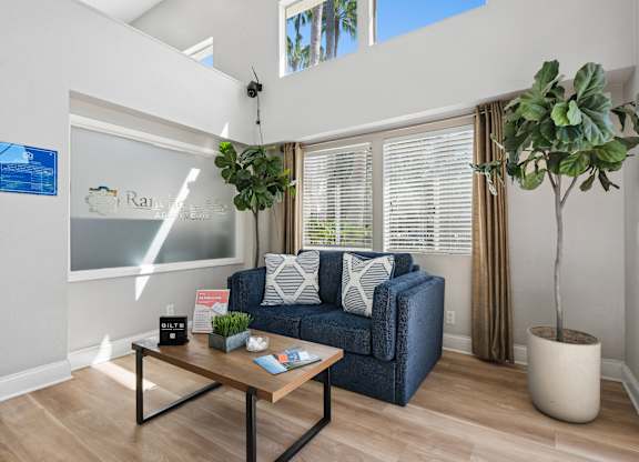 A living room with a blue couch and a wooden coffee table.