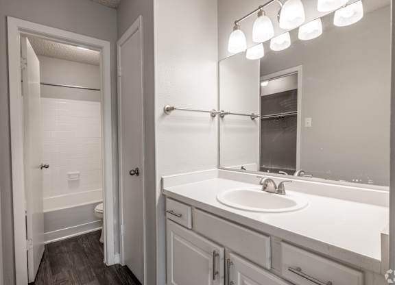 A bathroom with a white sink and a white toilet.