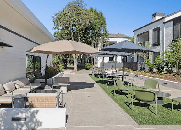 A patio with a table and chairs under umbrellas.