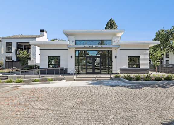 A white building with a black gate in front.