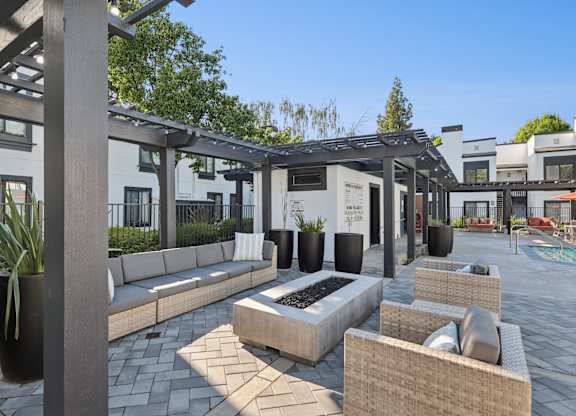 A patio area with a fire pit and seating.