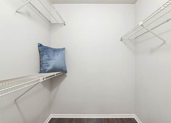 A white closet with a pillow on a shelf.