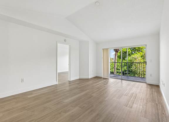 A room with wooden flooring and white walls.