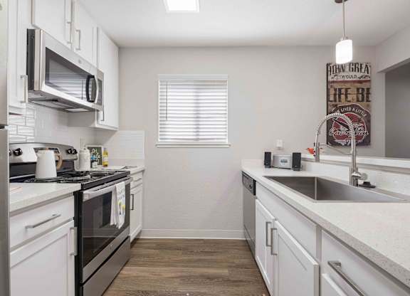 A kitchen with white cabinets and a black stove top oven.