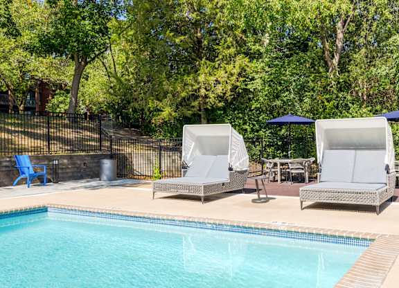 Two sun loungers sit on the edge of a pool.