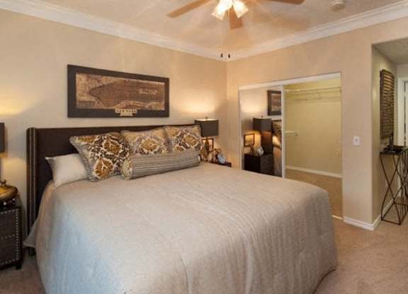 Apartments In Houston - San Montego - Spacious Bedroom With High Ceilings, Ceiling Fan, Carpet Flooring, And Large Walk-In Closet With Mirror Sliding Doors