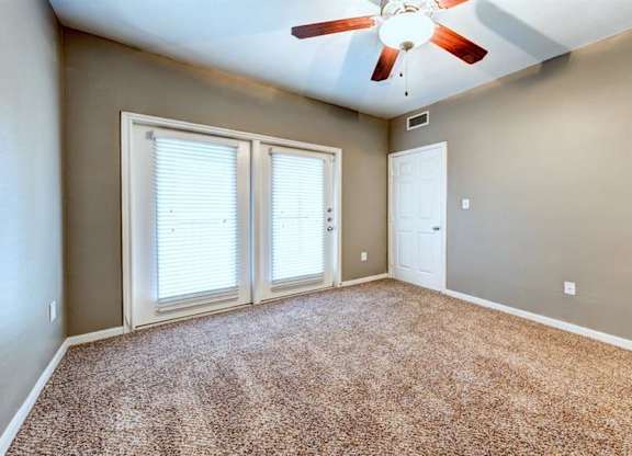 Bedroom with balcony doors and ceiling fan