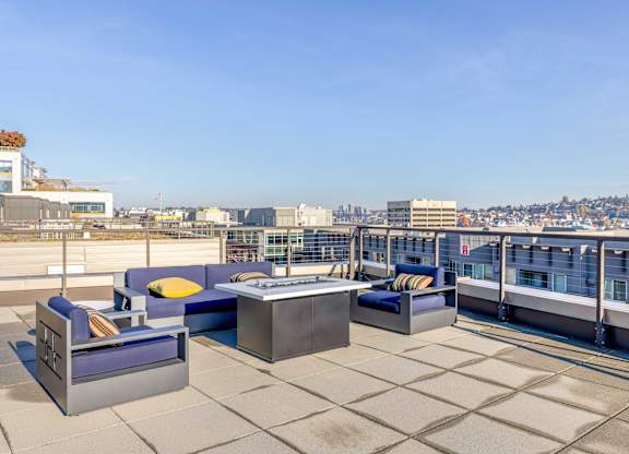 a terrace with couches and a table on a roof overlooking the city