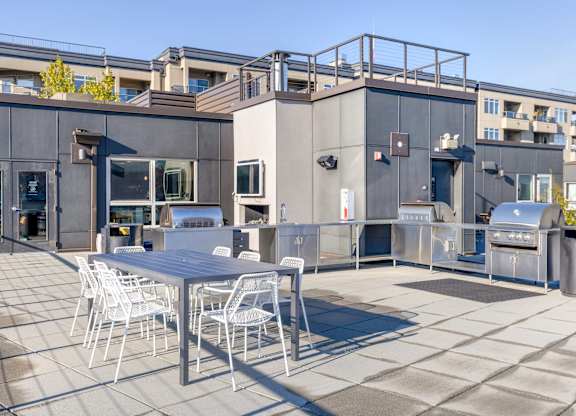 a patio with a table and chairs on the rooftop