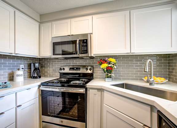 Apartments in Phoenix, AZ - Village at Lakewood Fully Equipped Kitchen with Stainless Steel Appliances and White Cabinetry