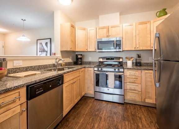 a kitchen with wooden cabinets and stainless steel appliances