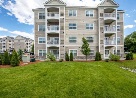 an apartment building with a large green lawn