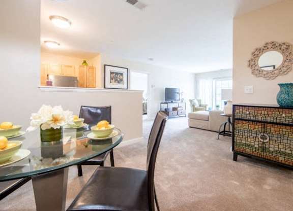 a living room with a glass table and chairs