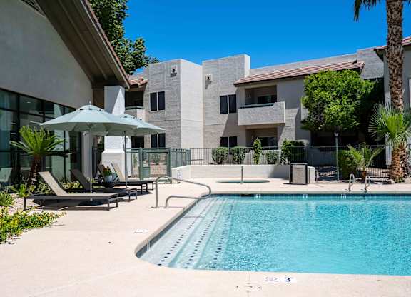 South Phoenix Apartments - Village at Lakewood - Sparkling Pool with Sun Lounge Chairs, Umbrellas, Hot Tub, and Palm Trees