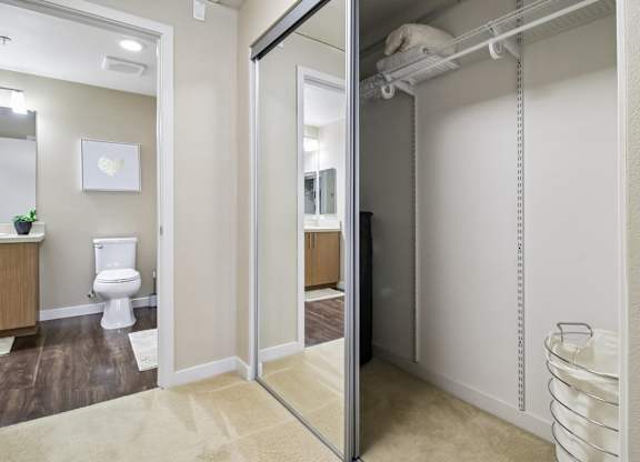 A bathroom with a toilet, sink, and a large mirror.