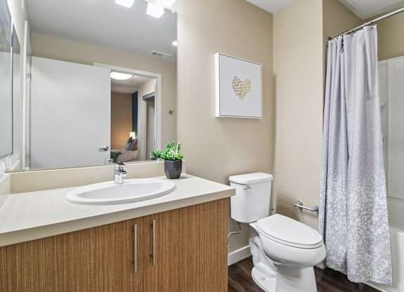 A bathroom with a white toilet, a sink, and a shower curtain.