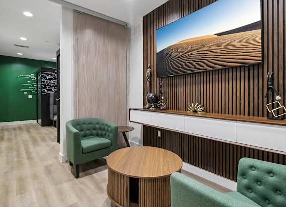 A room with a green chair and a wooden table.