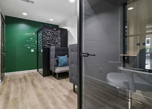 A modern office with a green wall and a glass partition.