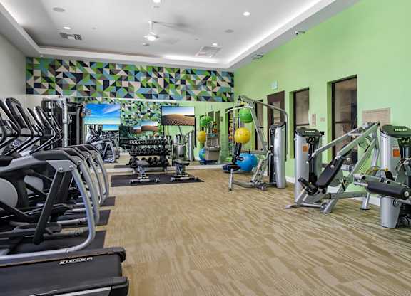 A gym with treadmills, weights, and exercise equipment.