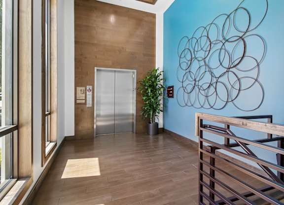 A hallway with a blue wall and a wooden floor.