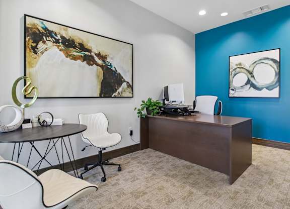 A room with a blue wall and a painting on it.