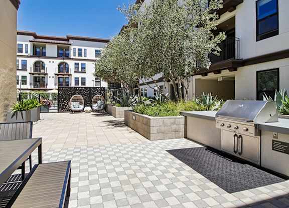 A patio with a grill and a table.