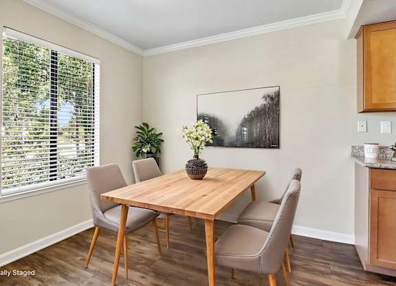 A dining room with a wooden table and chairs.