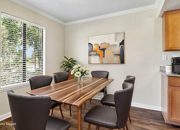 A dining room with a wooden table and chairs.