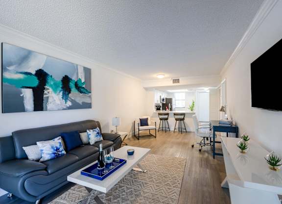 Apartments In Coconut Creek for Rent – Waterview at Coconut Creek – living room with a couch and a table and hardwood floors