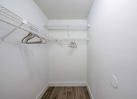 Coconut Creek Apartments – Waterview at Coconut Creek – empty closet with white walls and white hangers in a white room with wood