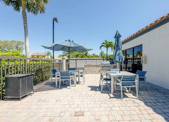 Coconut Creek Apartments – Waterview at Coconut Creek – patio with tables and chairs and umbrellas