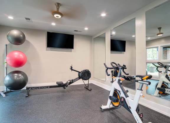 Apartments in Marietta Georgia for Rent – Wood Pointe Apartments - fitness center exercise bikes and a television mounted on the wall.