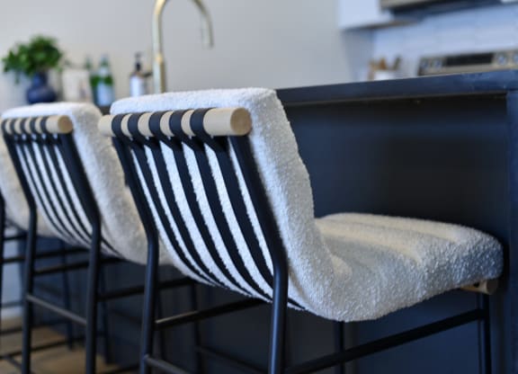 three black and white striped chairs with a white towel on the back