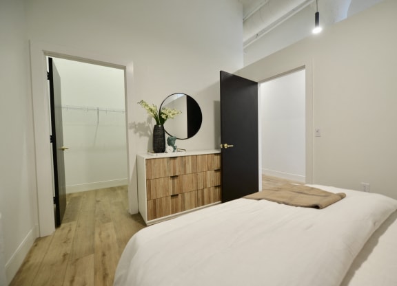 a bedroom with a bed and a dresser and a mirror
