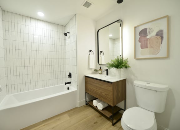 a bathroom with a toilet and a tub and a sink