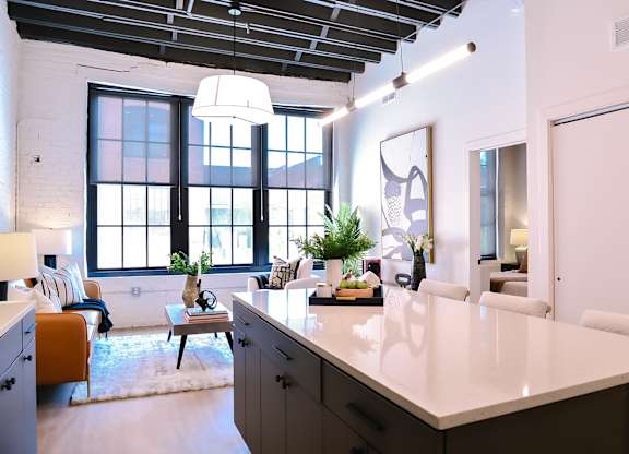 A kitchen with a large island and a dining table with chairs.