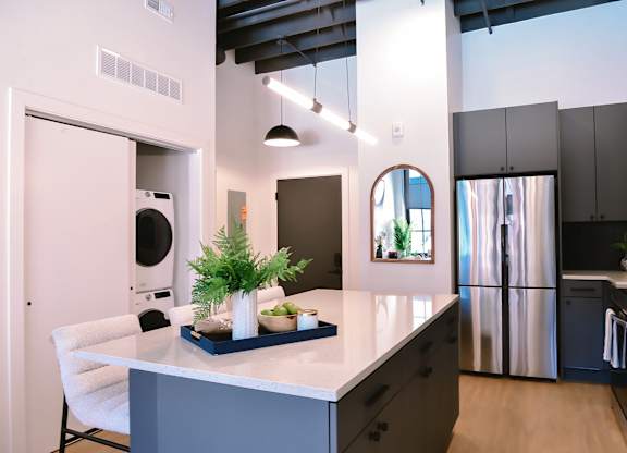 A kitchen with a white counter and a plant on it.