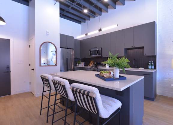 A kitchen with a bar area and striped chairs.