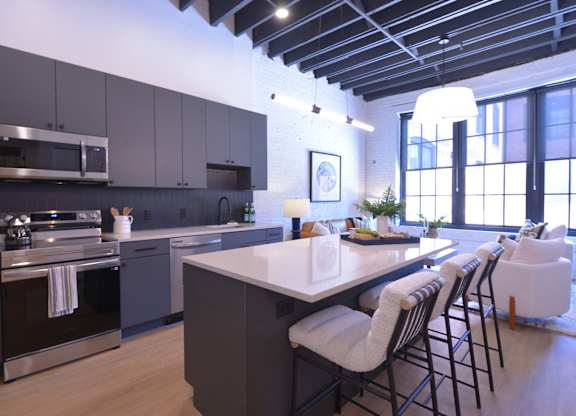 A modern kitchen with a large island and bar stools.