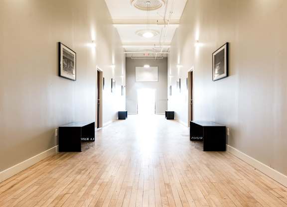 A long hallway with wooden floors and white walls.